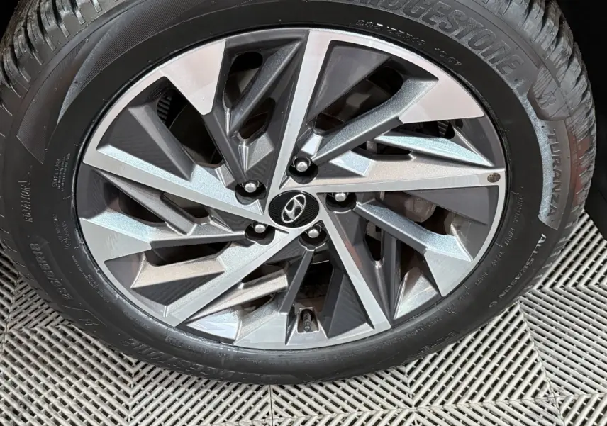 Gros plan sur la jante alliage argentée et noire avec logo Hyundai, montée sur pneu Bridgestone Turanza.