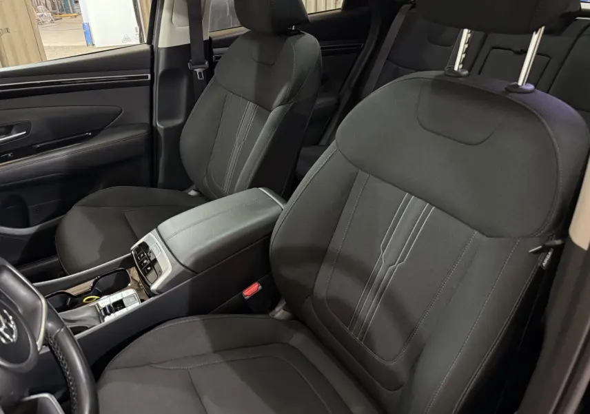 Intérieur noir du Hyundai Tucson 2021, vue rapprochée des sièges avant et console centrale moderne.