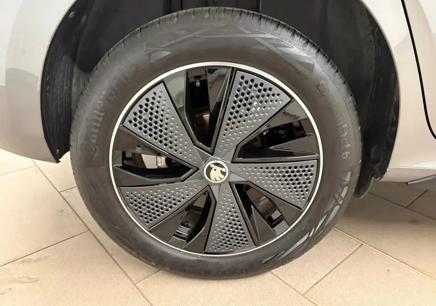 Gros plan sur la roue avant gauche du Skoda Kamiq Monte Carlo 2024 gris graphite avec jante noire et grise au design perforé.