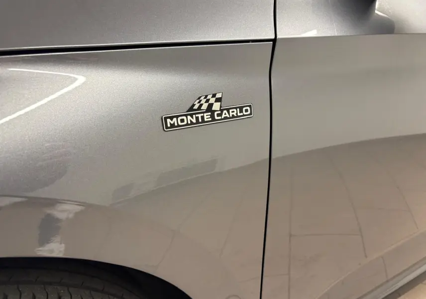 Gros plan sur l'aile avant gauche gris graphite d'un Skoda Kamiq Monte Carlo 2024 avec badge distinctif "Monte Carlo".