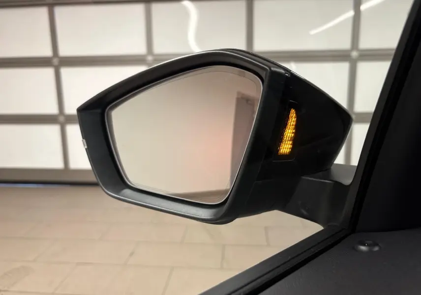 Rétroviseur extérieur droit du Skoda Kamiq 2024 gris graphite avec clignotant allumé, vue rapprochée intérieure.