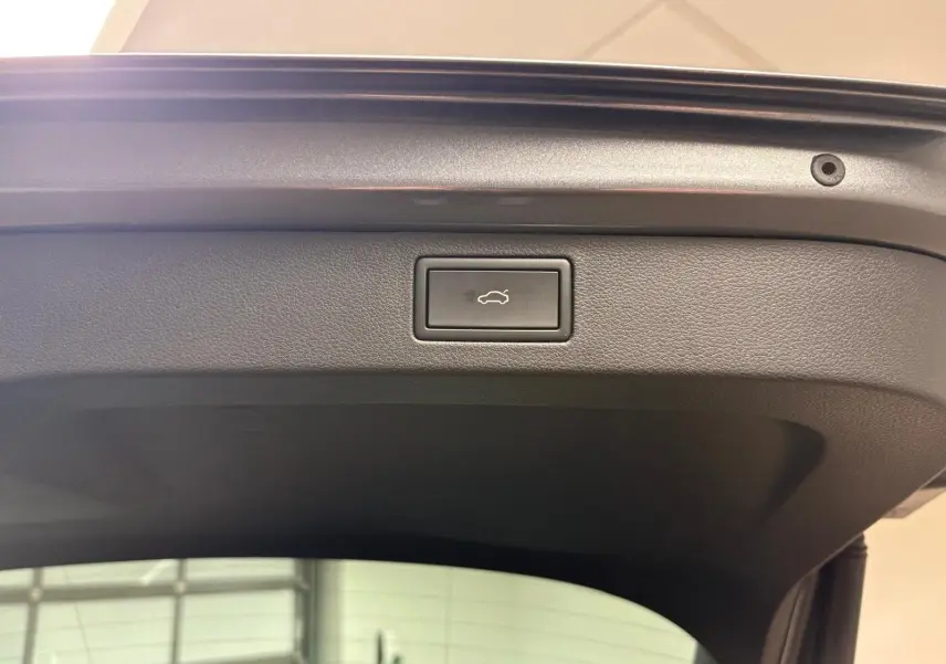 Bouton d'ouverture électrique du coffre sur la partie intérieure de la porte arrière d'un Skoda Kamiq gris graphite 2024.