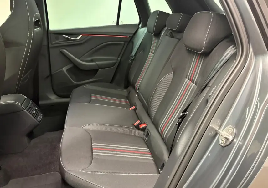 Vue intérieure côté droit des sièges arrière du Skoda Kamiq 2024 gris graphite avec surpiqûres rouges et noires.