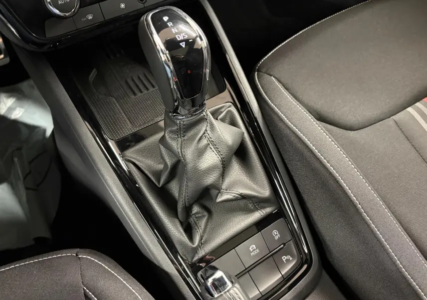 Le levier de vitesses automatique noir et chrome du Skoda Kamiq Monte Carlo 2024, avec console et siège gris graphite.
