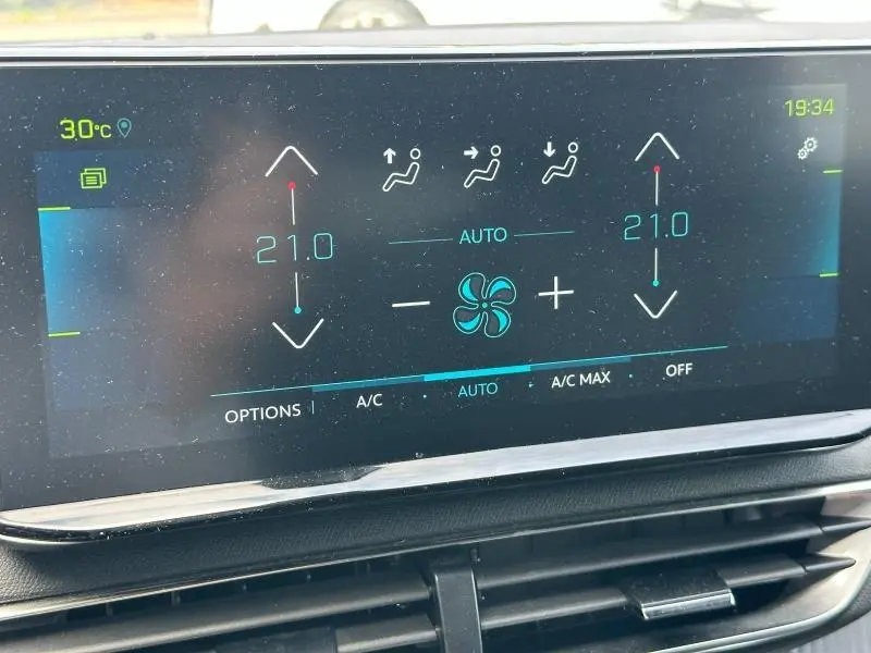 Écran tactile du système de climatisation automatique du Peugeot 3008 bleu, affichant 21°C en mode auto.