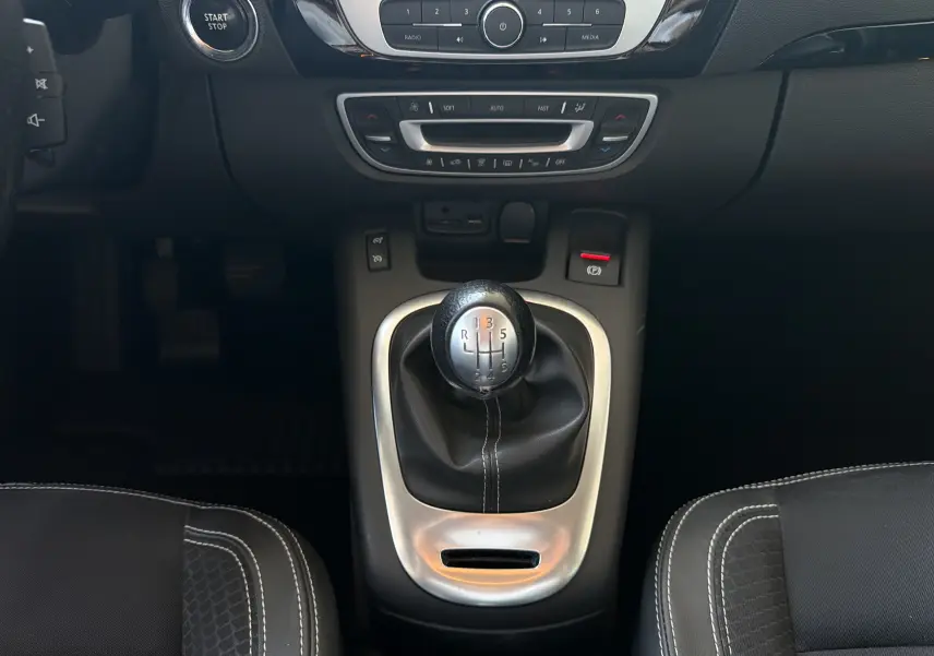Vue rapprochée du levier de vitesses manuel et de la console centrale noire du Renault Scénic gris Cassiopée 2015.