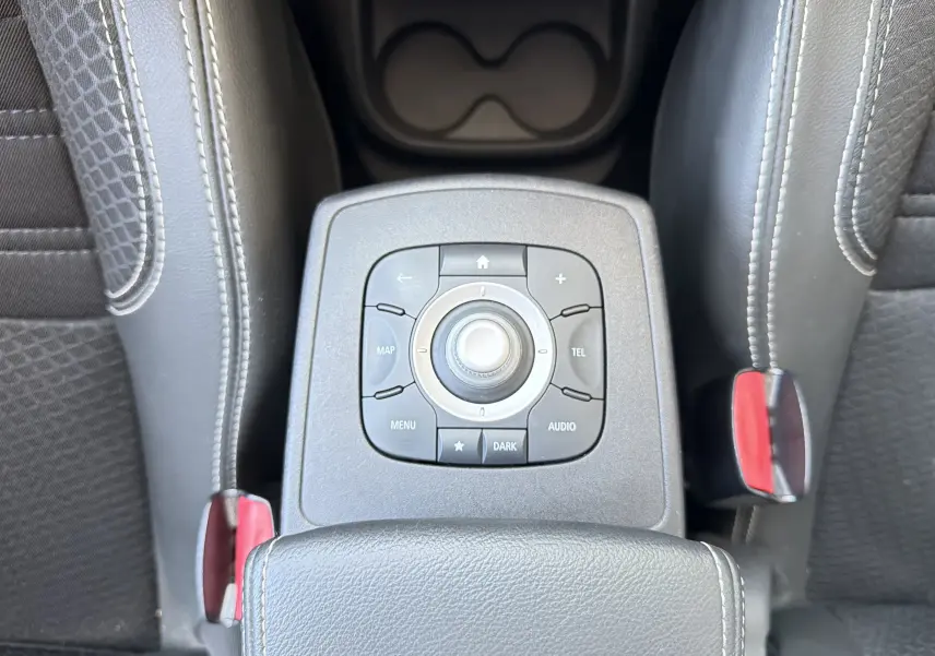 Vue plongeante sur la console centrale du Renault Scénic 1.5 dCi 110 Bose, avec commandes multimédia et sellerie noire.