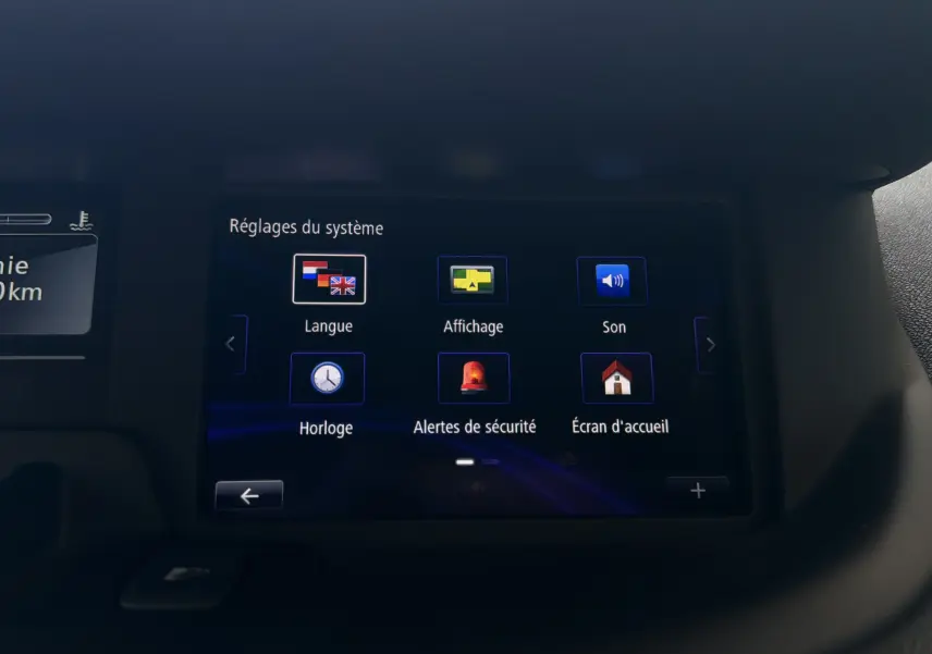Écran tactile du système de réglages du Renault Scenic gris Cassiopée, vue intérieure centrée sur les options de langue et sécurité.