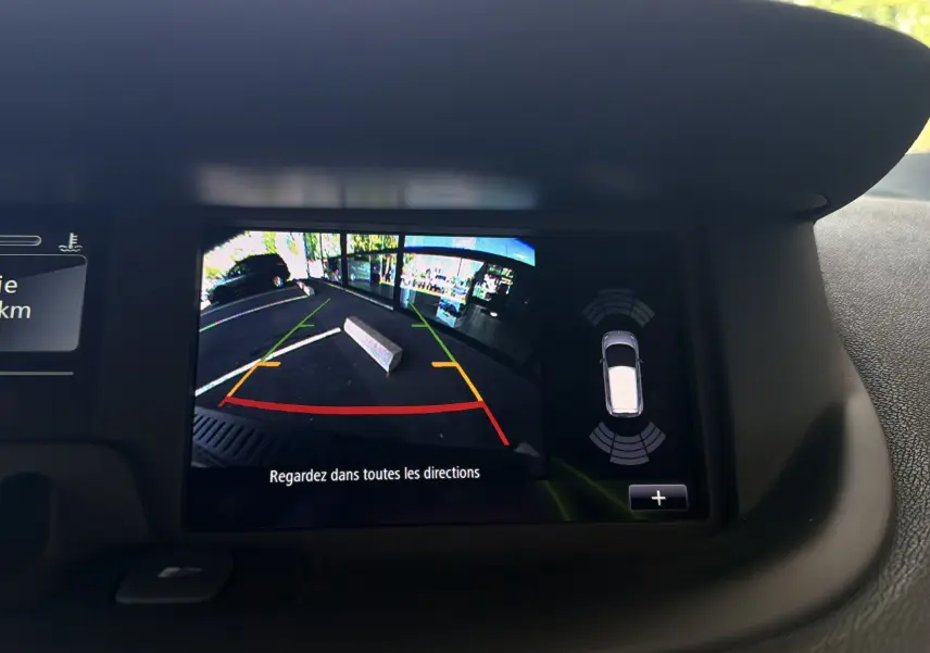 Écran de caméra de recul du Renault Scénic gris Cassiopée montrant un obstacle derrière le véhicule en parking.