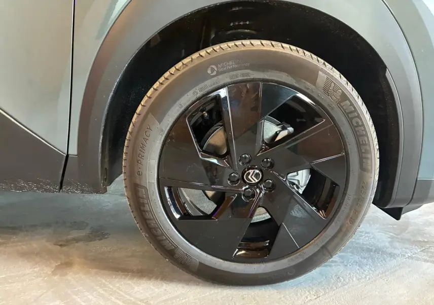 Gros plan sur la roue avant gauche noire brillante du Citroën C5 Aircross vert Astoria Metal, avec logo Citroën au centre.