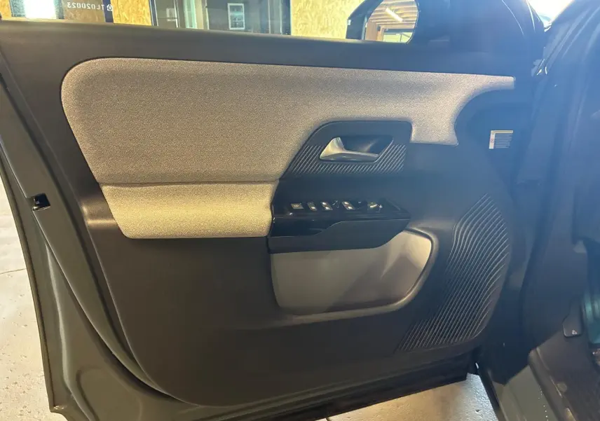 Vue intérieure côté gauche de la porte avant du Citroën C5 Aircross 2026, avec panneau bicolore gris clair et noir.