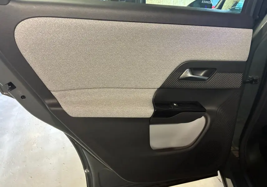 Vue intérieure côté gauche de la porte arrière du Citroën C5 Aircross 2026, tissu gris clair et plastique noir.