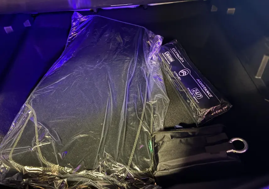 Vue du coffre du Citroën C5 Aircross 2026 vert Astoria Metal avec tapis de sol et kit d'assistance emballés.