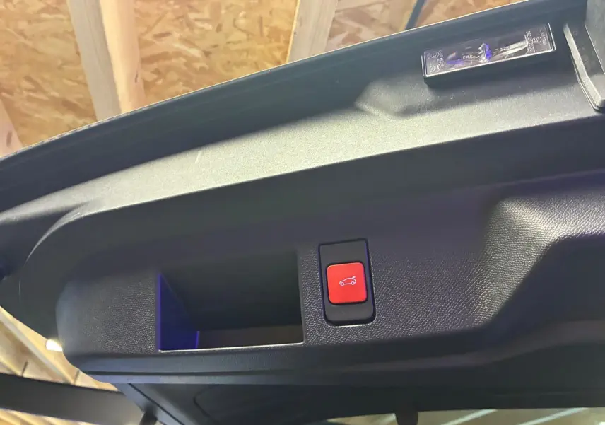 Bouton rouge d'ouverture électrique du coffre sur le hayon intérieur d'un Citroën C5 Aircross 2026 vert Astoria Metal.
