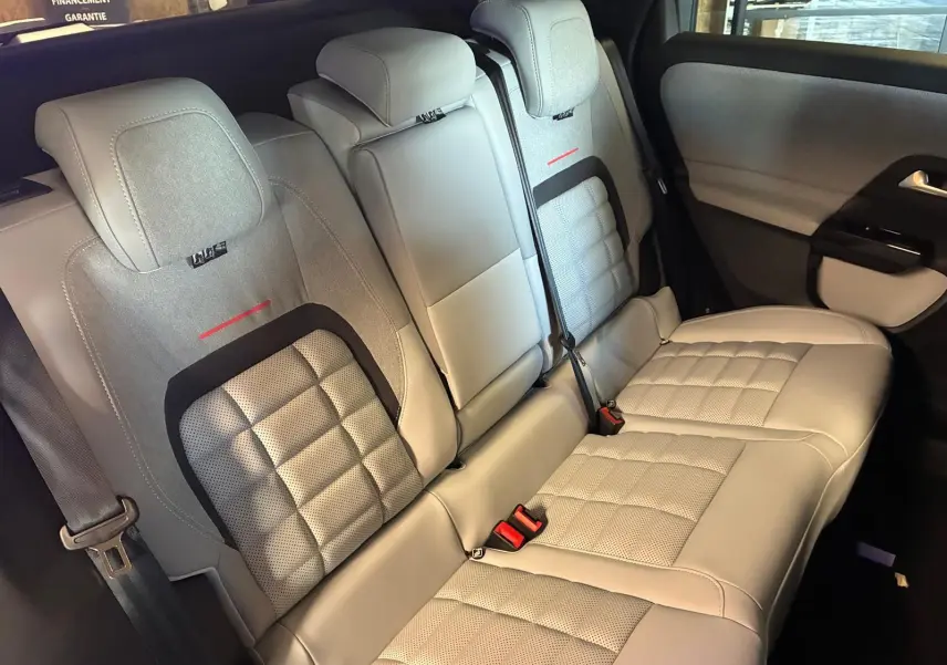 Vue intérieure des sièges arrière gris clair du Citroën C5 Aircross 2026, avec surpiqûres et ceintures visibles.