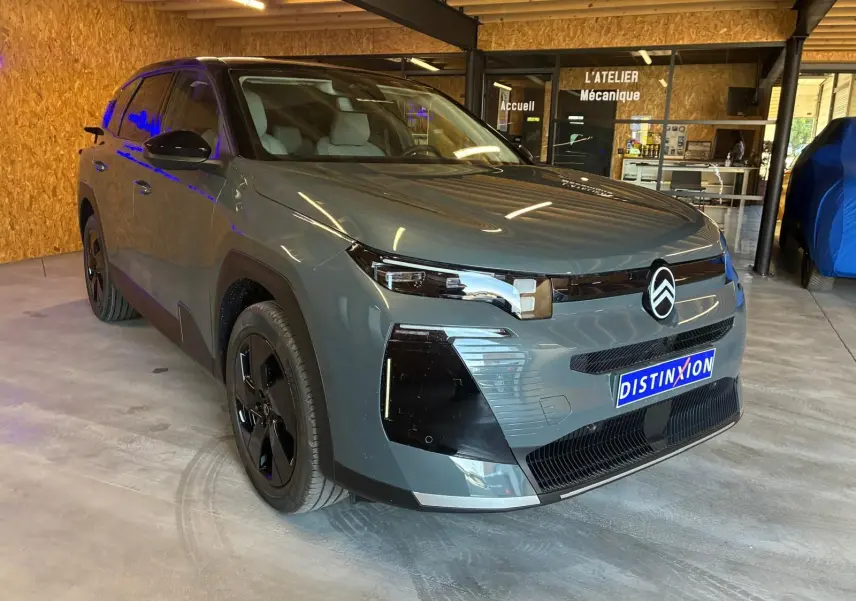 Citroën C5 Aircross 1.2 Hybrid 145 BVA Max vert Astoria métal, vue 3/4 avant droit en intérieur d'atelier.