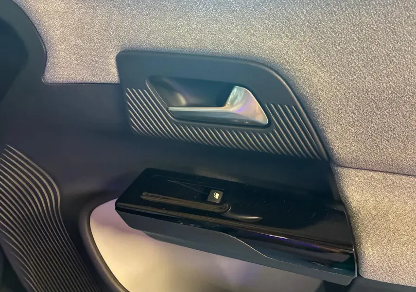 Détail de la poignée intérieure côté gauche avec commande de vitre noire sur porte gris clair du Citroën C5 Aircross 2026.