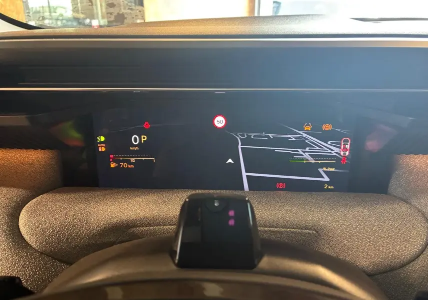 Vue intérieure du tableau de bord numérique du Citroën C5 Aircross 1.2 Hybrid 145 BVA, affichage de navigation et informations de conduite.
