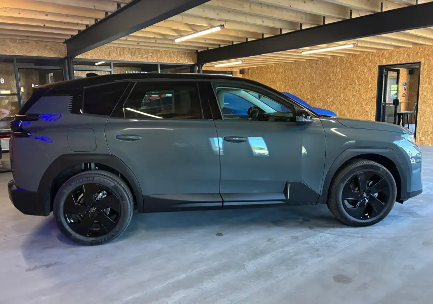 Vue latérale droite d'un Citroën C5 Aircross 1.2 Hybrid 145 BVA Max vert Astoria métal avec jantes noires en intérieur.