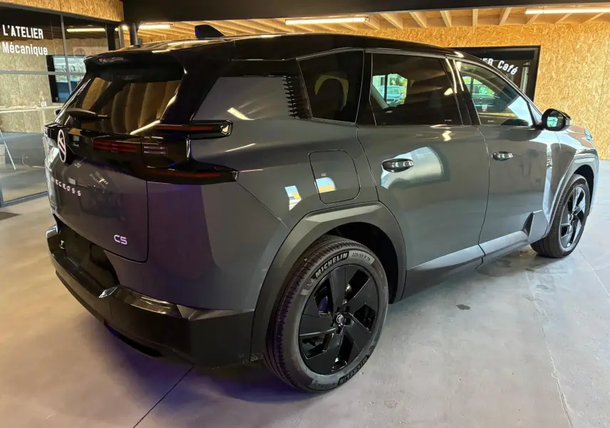 Vue 3/4 arrière droite du Citroën C5 Aircross 2026 vert Astoria métallisé avec jantes noires et toit noir.