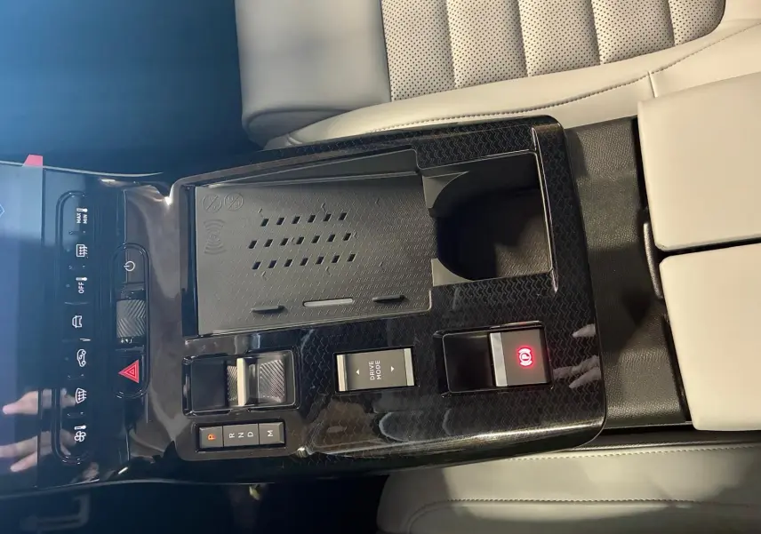 Vue rapprochée de la console centrale du Citroën C5 Aircross 2026, finition noir brillant avec commandes et accoudoir beige.