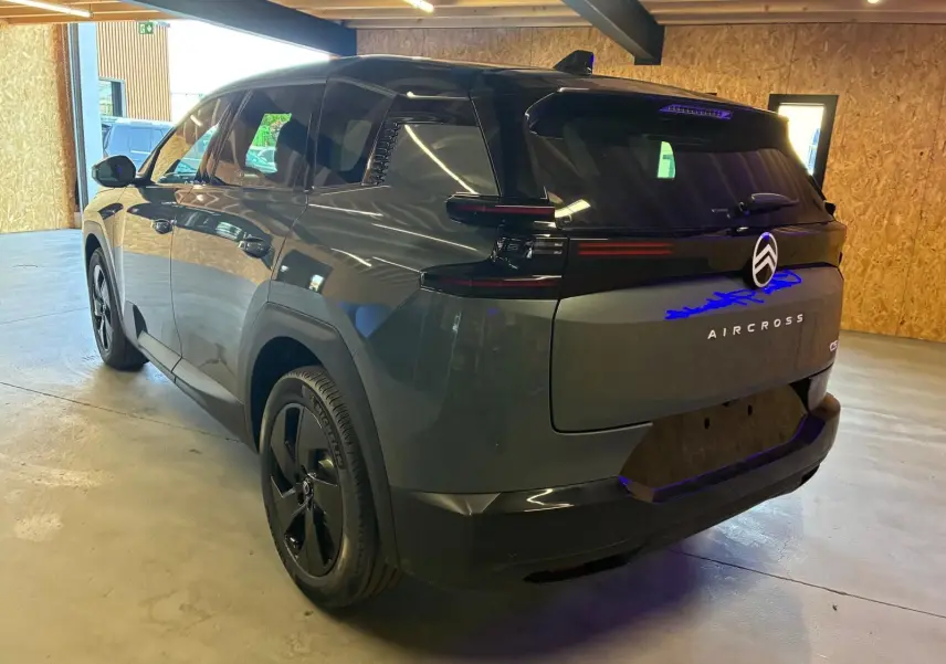 Vue 3/4 arrière droite du Citroën C5 Aircross 2026 vert Astoria métallisé avec feux arrière noirs et jantes noires.