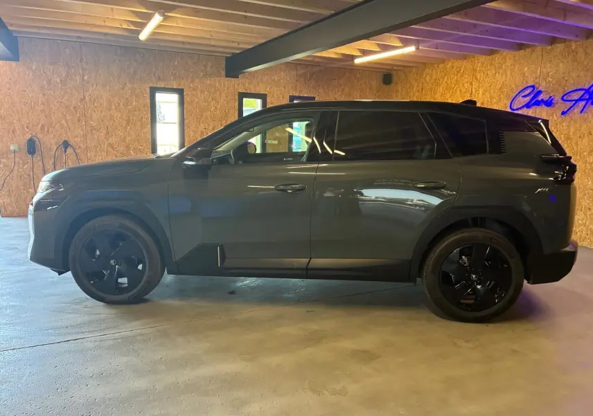 Vue latérale droite du Citroën C5 Aircross 2026 vert Astoria métallisé avec jantes noires dans un garage éclairé.