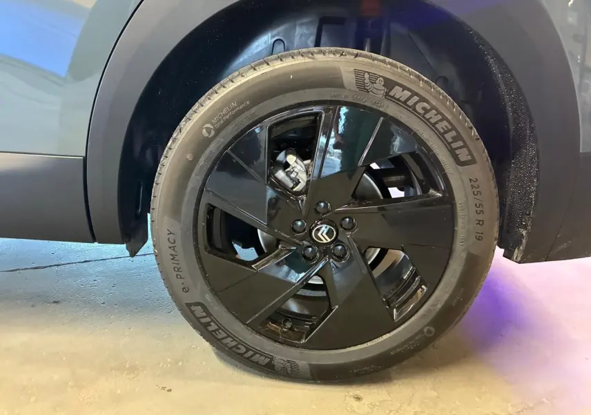 Gros plan sur la roue arrière droite du Citroën C5 Aircross 1.2 Hybrid 145 BVA Max vert Astoria, jante noire brillante 19 pouces.