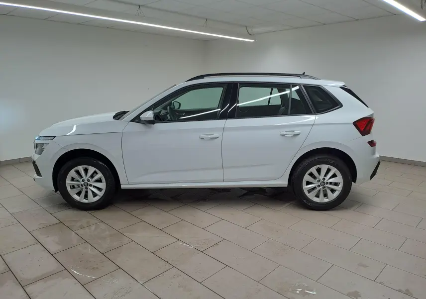 Vue latérale droite du SUV blanc SKODA KAMIQ 1.0 TSI 116 DSG7 2025 avec toit noir et jantes alliage.