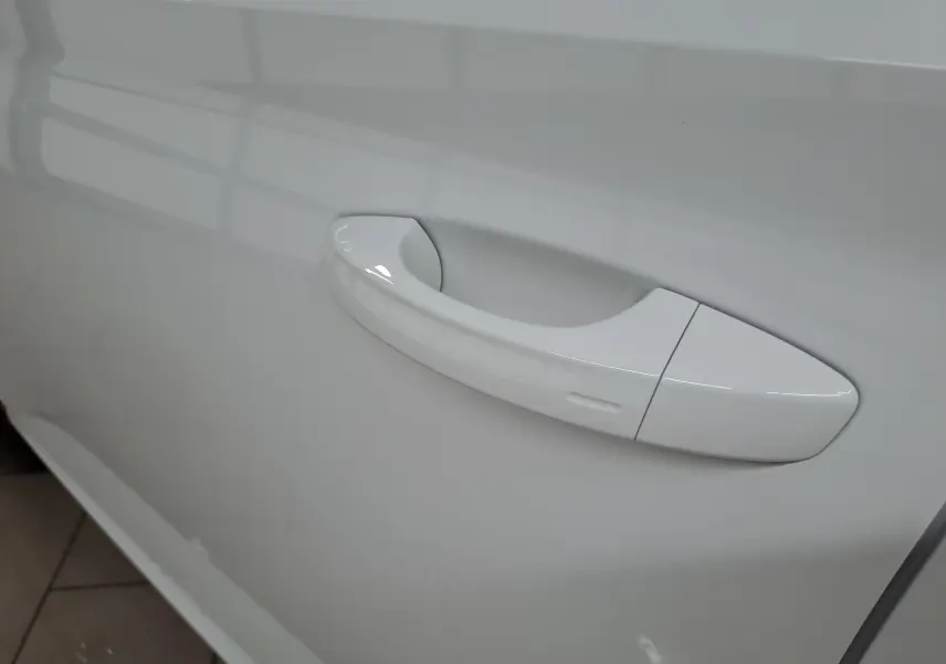 Poignée de porte blanche Lune en gros plan sur le côté gauche du Skoda Kamiq 2025 finition Selection.