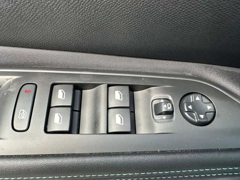 Commande des vitres électriques et réglage des rétroviseurs sur la porte côté conducteur d’un Peugeot 3008 noir Perla Nera.