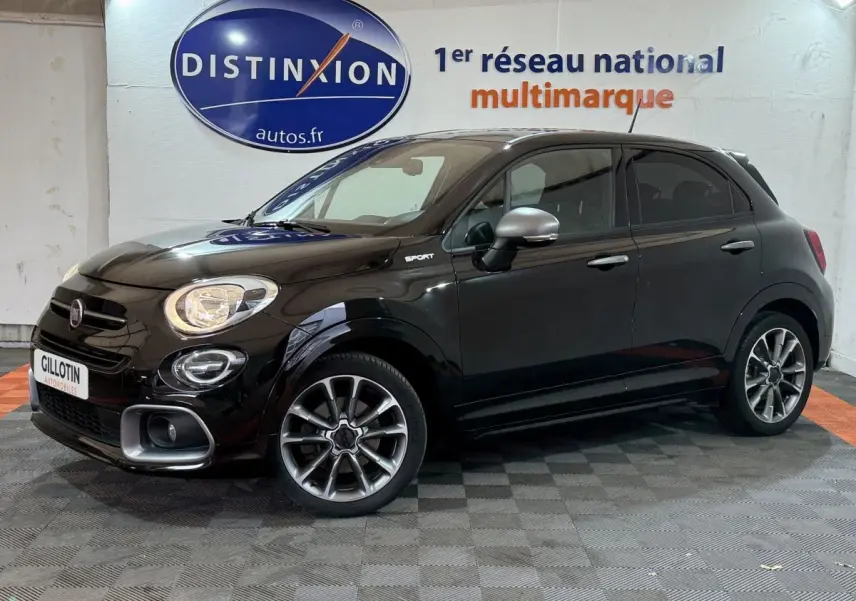Vue de profil droit d'une FIAT 500X noire finition Sport avec jantes alliage et rétroviseurs argentés dans un showroom.
