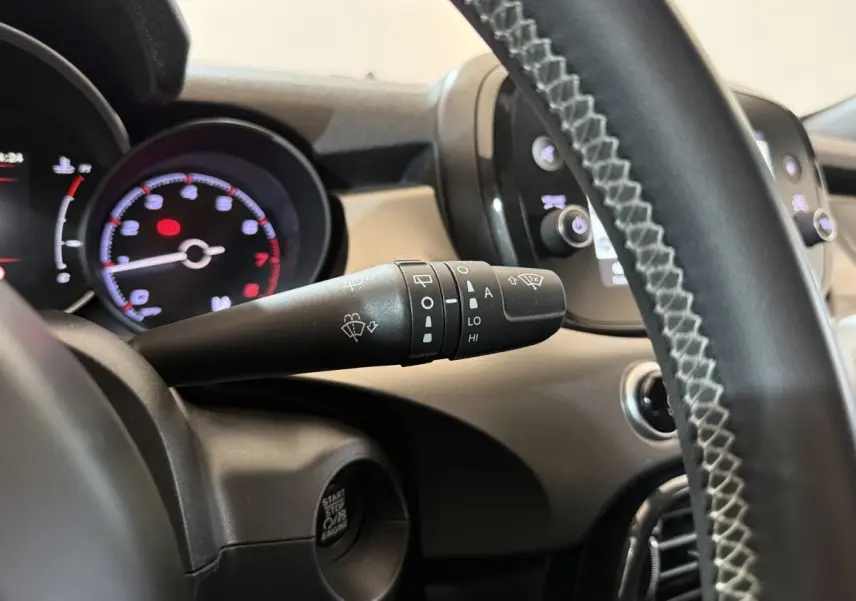 Gros plan sur la manette d’essuie-glace côté gauche du tableau de bord noir du Fiat 500X 2021, volant cuir visible.