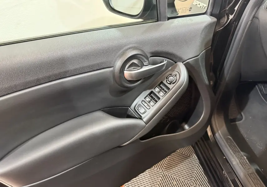Vue rapprochée de la porte avant gauche noire de la FIAT 500X Sport avec commandes électriques et poignée alu.