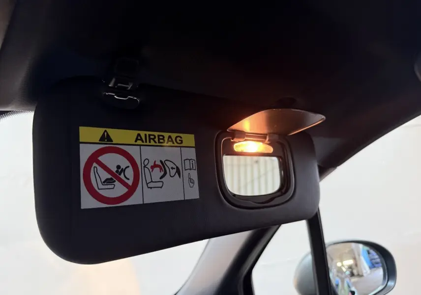 Miroir de courtoisie éclairé sur pare-soleil côté conducteur dans l’habitacle noir du Fiat 500X 2021.