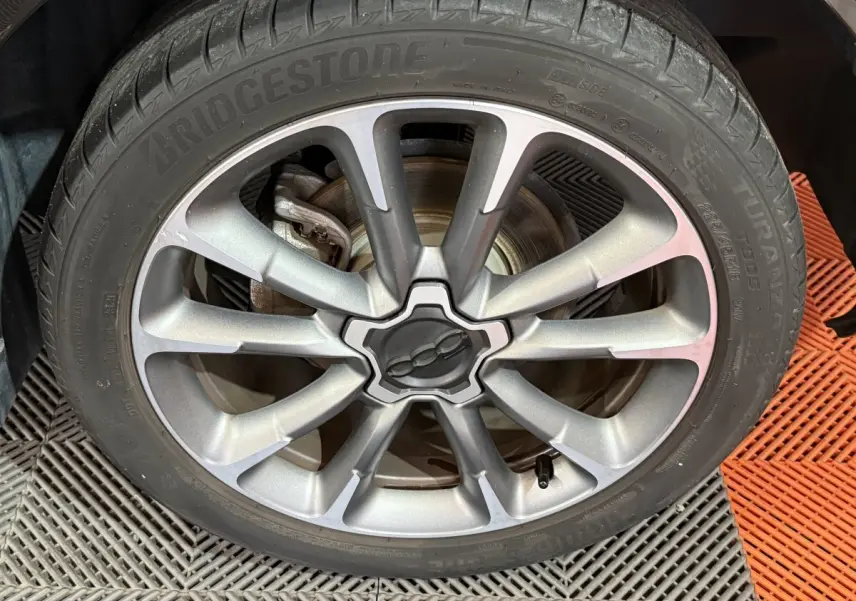 Gros plan sur la jante argentée du FIAT 500X 2021 avec logo central et pneu Bridgestone Turanza.