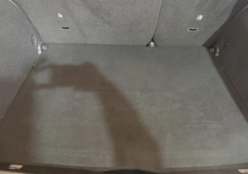 Coffre noir spacieux du Fiat 500X 2021, vue intérieure arrière avec banquette rabattue partiellement visible.