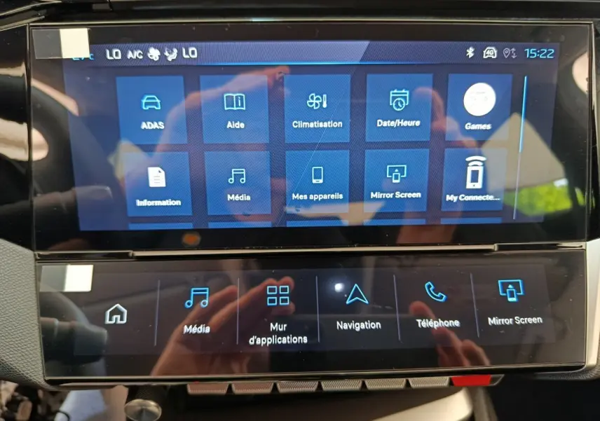Écran tactile central du tableau de bord de la Peugeot 308 blanche, affichant les menus multimédias et navigation.