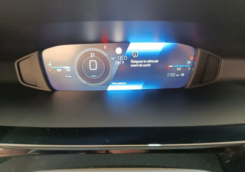 Affichage numérique du combiné d'instruments de la Peugeot 308 2026, avec indication vitesse, autonomie et message d'arrêt véhicule.