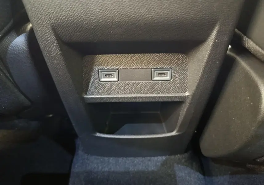 Vue rapprochée de la console arrière noire avec deux ports USB-C et un rangement sur Peugeot 308 blanc 2026.