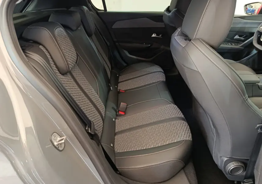 Vue intérieure côté gauche montrant la banquette arrière tissu et cuir gris d'une Peugeot 308 blanche 2026.