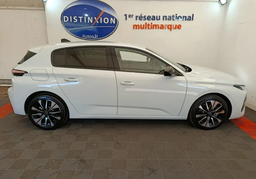 Vue de profil côté gauche d'une Peugeot 308 blanche 2026 avec jantes alliage noires et vitres teintées.