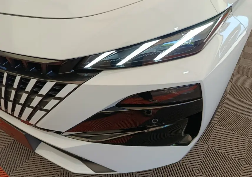 Gros plan sur l'avant droit blanc de la Peugeot 308 2026, mettant en valeur les phares LED et la calandre distinctive.