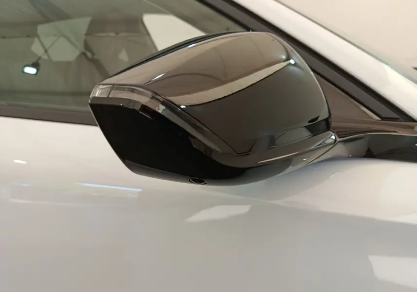 Rétroviseur noir en gros plan côté gauche sur Peugeot 308 blanche, version BlueHDi 130 CH EAT8 Allure 2026.