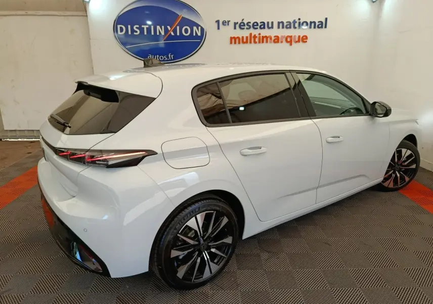 Peugeot 308 BlueHDi 130 blanc vue 3/4 arrière droit avec jantes noires et feux arrière LED distinctifs.