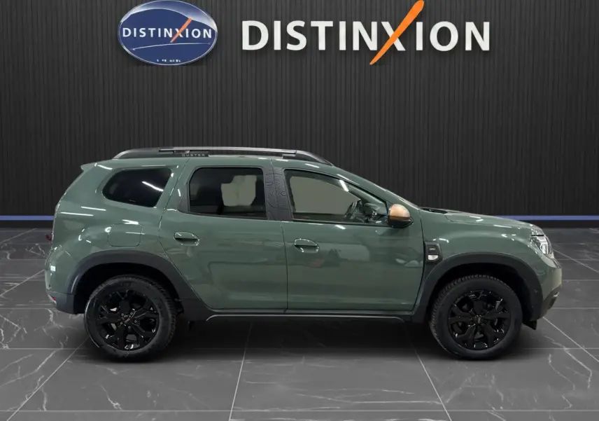Profil gauche du Dacia Duster 2024 kaki lichen avec jantes noires et rétroviseur couleur bronze.
