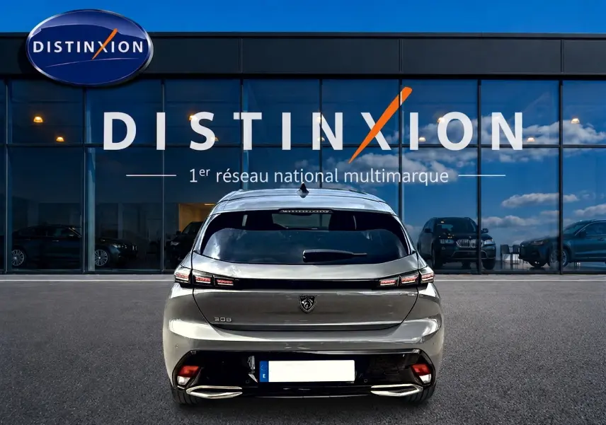 Vue arrière d'une Peugeot 308 gris selenium 2025 avec feux LED et double sortie d'échappement chromée.