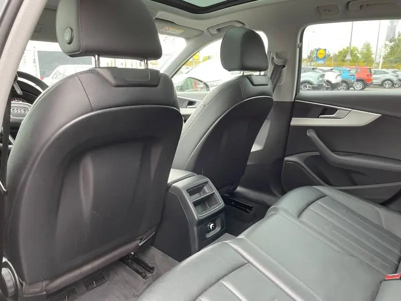 Vue arrière intérieure de l'Audi A4 Avant 2019 avec sièges cuir Milano noir et toit ouvrant panoramique.