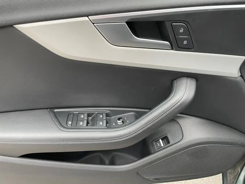 Gros plan sur la porte côté gauche de l'Audi A4 Avant 2019 avec garniture cuir noir et inserts aluminium ellipse argent.