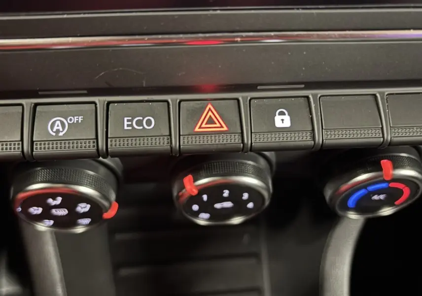 Gros plan sur la console centrale de la Renault Clio 2024 bleu iron, montrant les commandes de climatisation et les boutons de fonction.